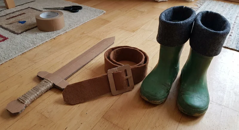 Kartonowy miecz, filcowy pas i zielone kalosze z szarymi, filcowymi mankietami jako elementy stroju Kota w Butach.